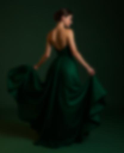 A model elegantly posing in a dark green Bondi Evening Dress, highlighting its flowing design and luxurious fabric.